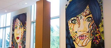 Murales avec visages exposées à la cafétéria du cégep