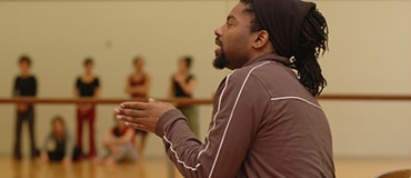 chorégraphe qui dirige une troupe d'élèves en danse