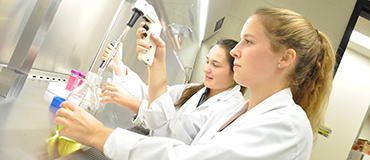 2 filles en sarrau dans laboratoire