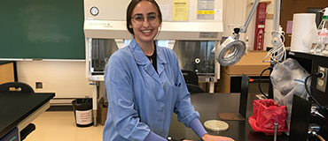 Coralie Guilmette en laboratoire et porte le sarrau bleu