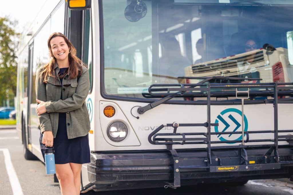 Étudiante devant un autobus de la STS